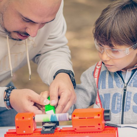 Vater und Sohn arbeiten mit der PLAYmake Drechselbank und bemalen ein Werkstück