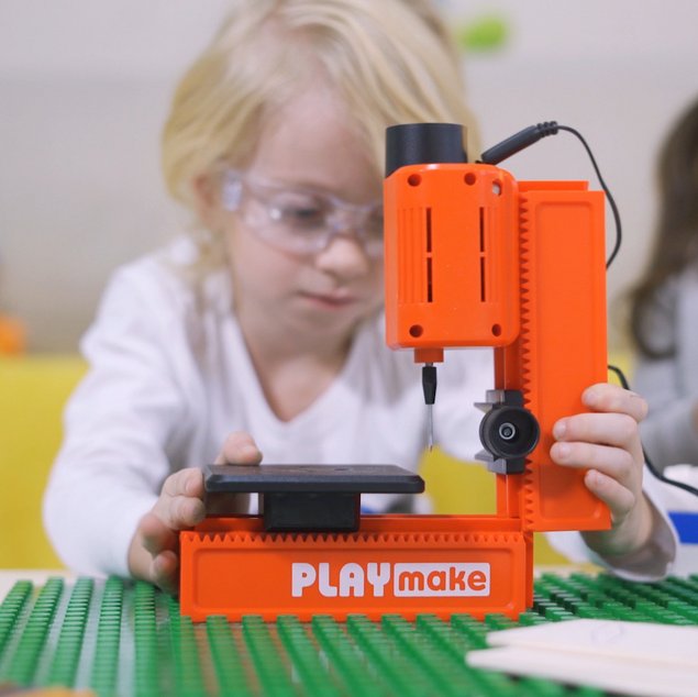 Kind baut die PLAYmake Standbohrmaschine auf einem Tisch zusammen